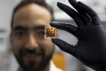 PS Solar_013025-3.jpg male researcher wearing a black glove holds a solar cell prototype